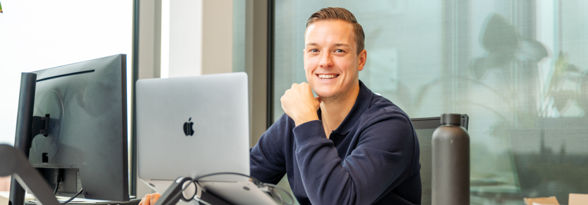 Vrolijke collega aan het werk achter zijn bureau